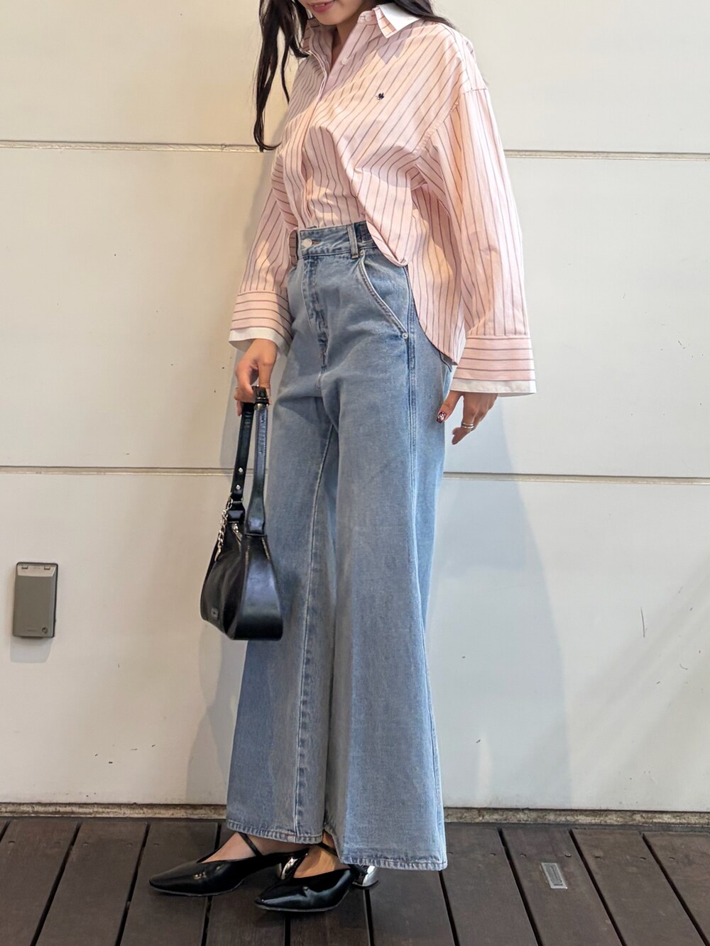 ピンク系のシャツ/ブラウス、ブルー系のデニムパンツ、ブラック系のハンドバッグを着用したレディースの春コーディネートの4枚目の写真