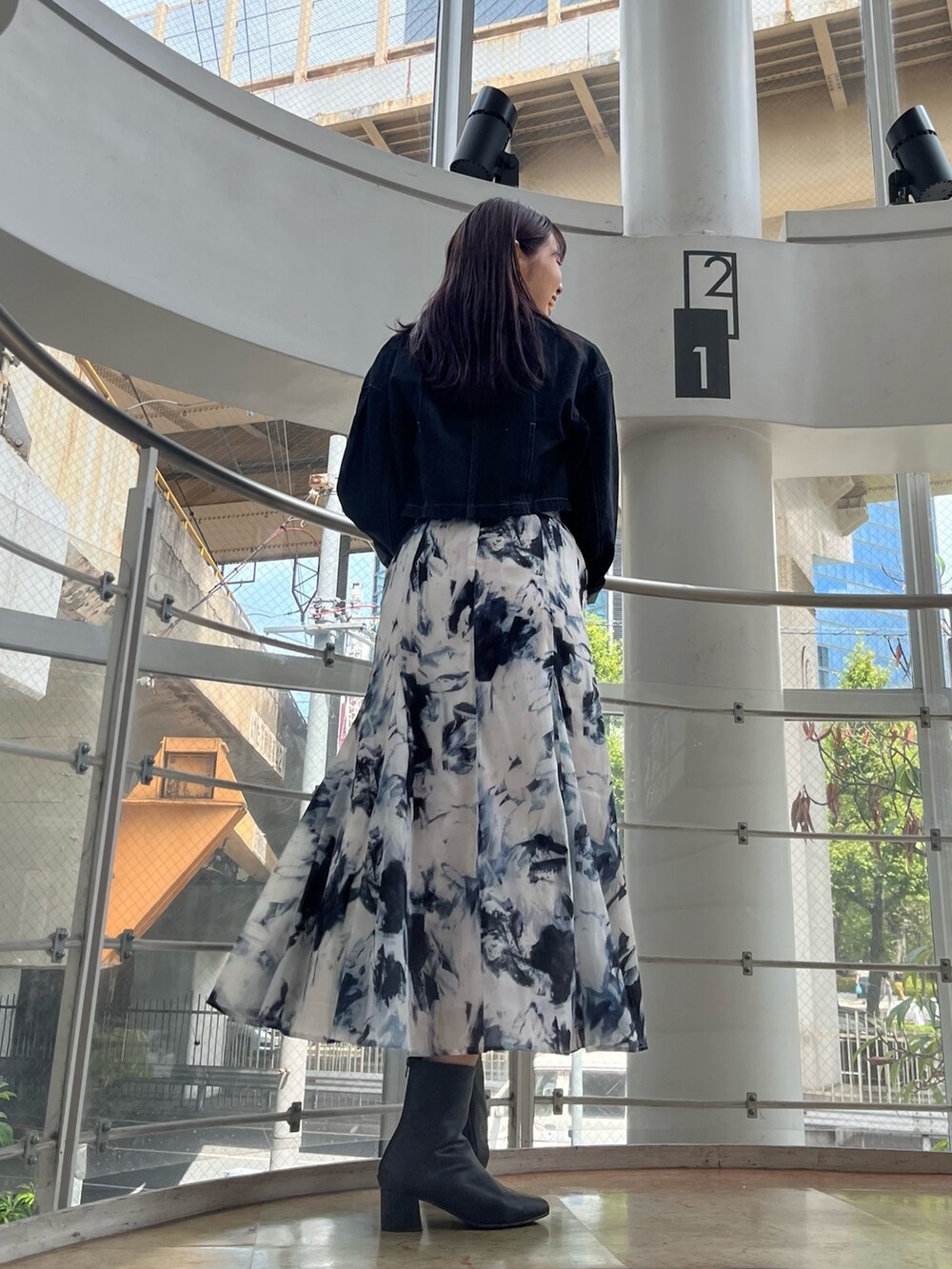 ブルー系のハンドバッグ、ブルー系のTシャツ/カットソー、ブラック系のデニムジャケットを着用したレディースの秋コーディネートの4枚目の写真