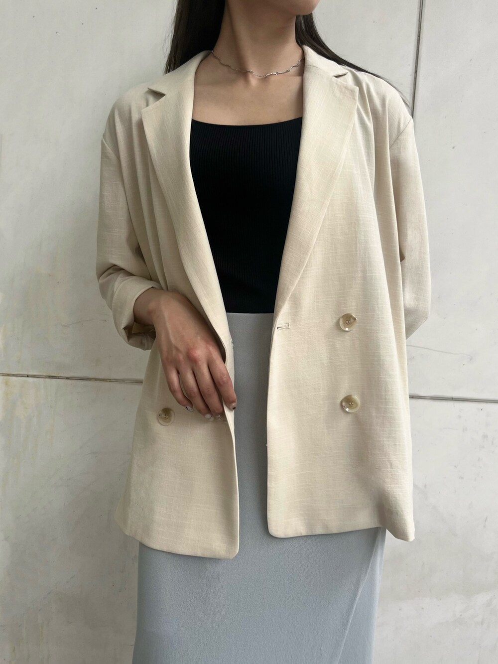 ブルー系のスカート、ホワイト系のショルダーバッグ、ベージュ系のテーラードジャケットを着用したレディースの夏コーディネートの6枚目の写真