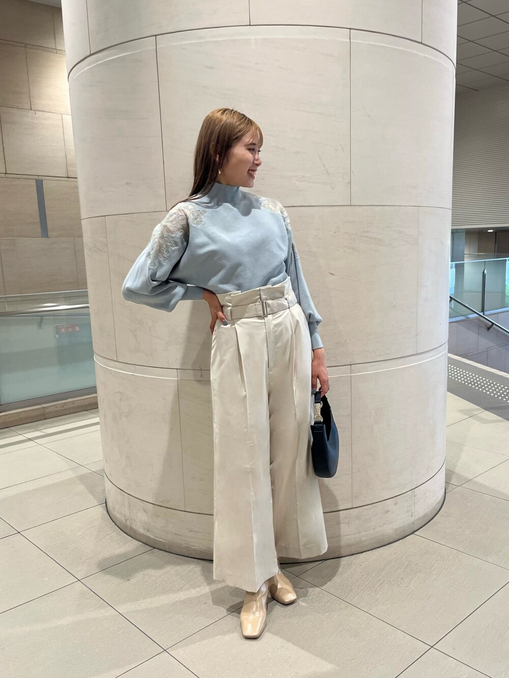 グリーン系のニット/セーター、ホワイト系のその他パンツ、ブラック系のハンドバッグを着用したレディースの秋コーディネートの2枚目の写真