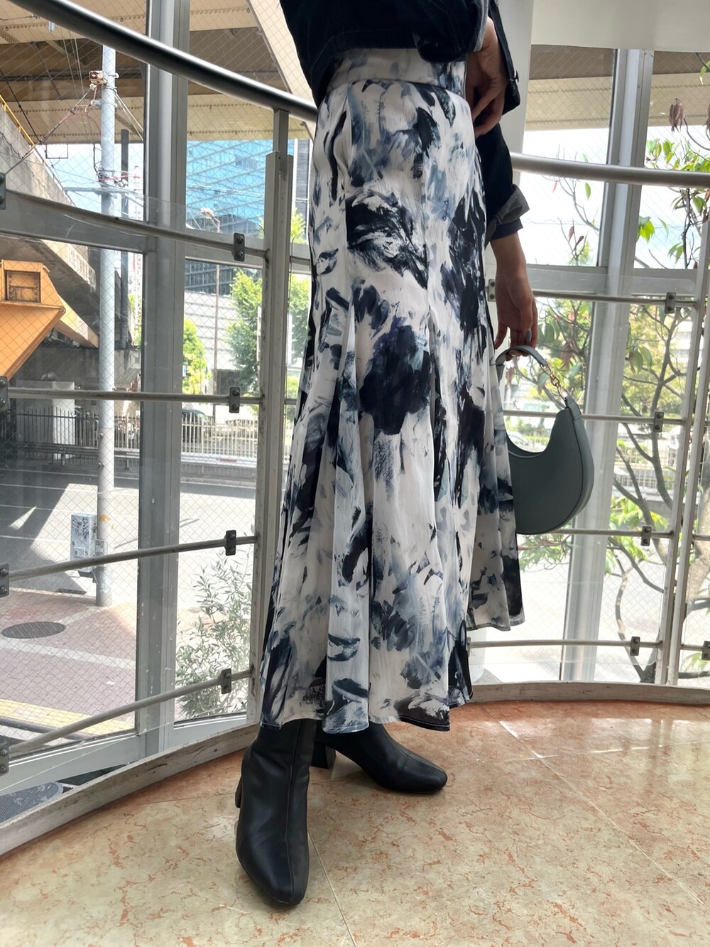 ブルー系のハンドバッグ、ブルー系のTシャツ/カットソー、ブラック系のデニムジャケットを着用したレディースの秋コーディネートの8枚目の写真