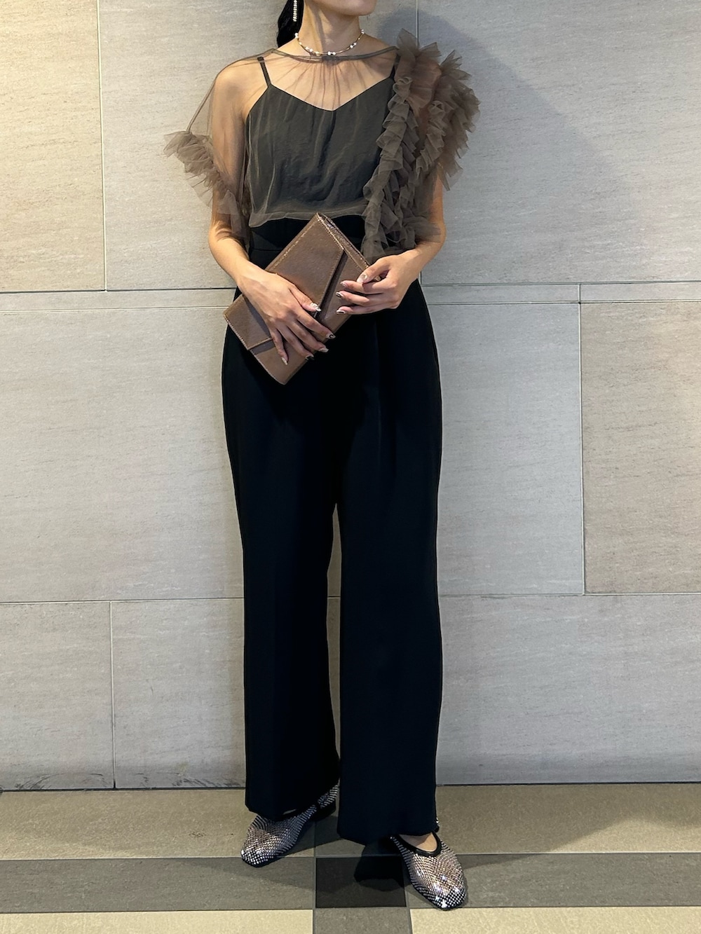 ゴールド系のクラッチバッグ、ブラック系のパンプス、その他のパンツドレスを着用したレディースの秋コーディネートの4枚目の写真