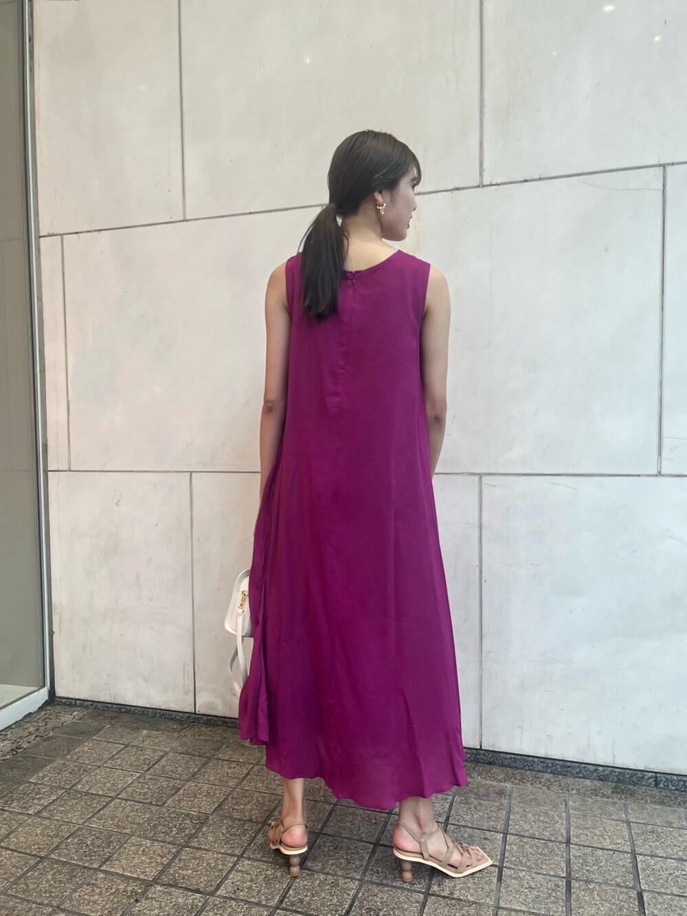 パープル系のワンピース、ホワイト系のショルダーバッグ、ベージュ系のサンダルを着用したレディースの夏コーディネートの2枚目の写真