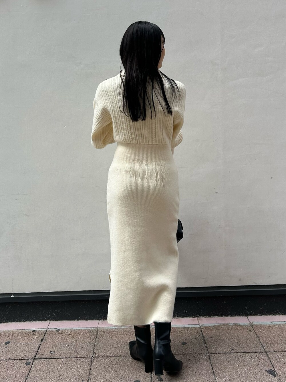 ホワイト系のワンピース、ブラック系のブーツ、ブラック系のショルダーバッグを着用したレディースの秋コーディネートの2枚目の写真