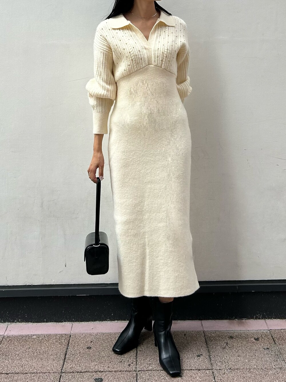 ホワイト系のワンピース、ブラック系のブーツ、ブラック系のショルダーバッグを着用したレディースの秋コーディネートの3枚目の写真