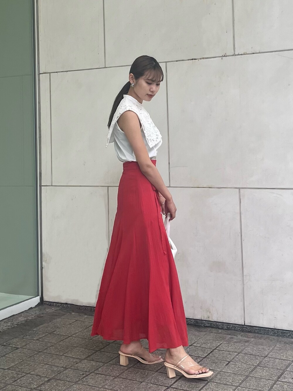 レッド系のスカート、ホワイト系のシャツ/ブラウスを着用したレディースの夏コーディネートの2枚目の写真