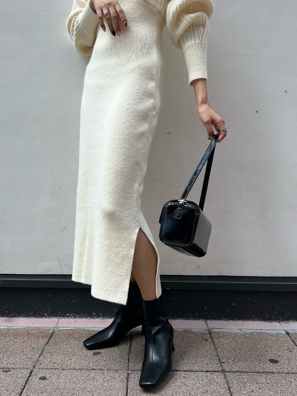 ホワイト系のワンピース、ブラック系のブーツ、ブラック系のショルダーバッグを着用したレディースの秋コーディネートの6枚目の写真