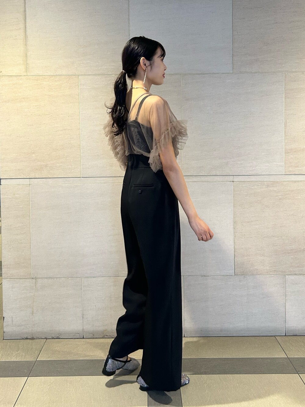 ゴールド系のクラッチバッグ、ブラック系のパンプス、その他のパンツドレスを着用したレディースの秋コーディネートの3枚目の写真