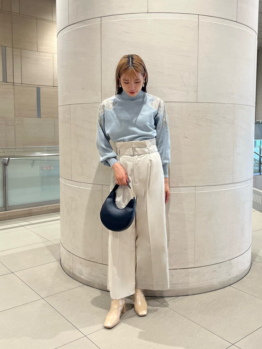 グリーン系のニット/セーター、ホワイト系のその他パンツ、ブラック系のハンドバッグを着用したレディースの秋コーディネートの3枚目の写真