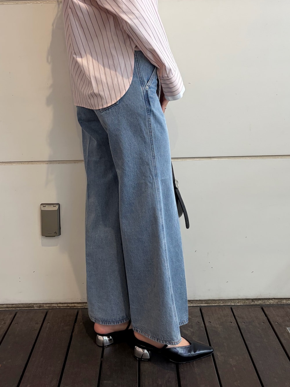 ピンク系のシャツ/ブラウス、ブルー系のデニムパンツ、ブラック系のハンドバッグを着用したレディースの春コーディネートの6枚目の写真