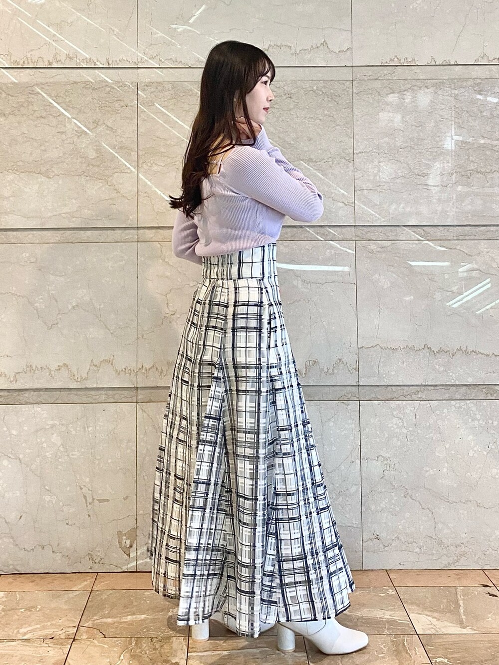 パープル系のニット/セーター、ホワイト系のスカート、ホワイト系のブーツを着用したレディースの冬コーディネートの5枚目の写真