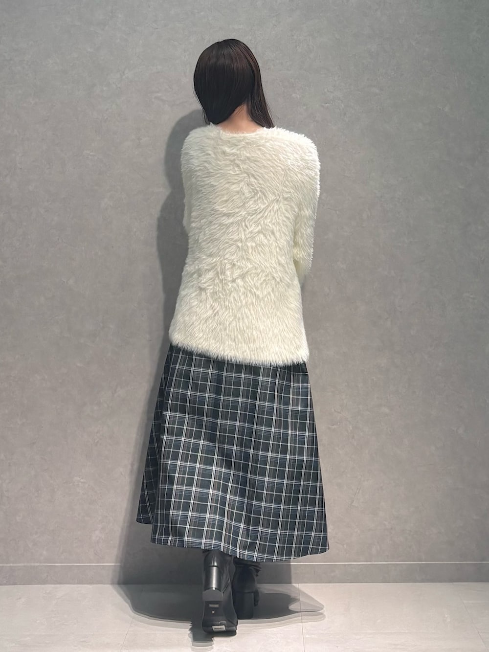 グリーン系のワンピース、ブラック系のハンドバッグ、ブラック系のブーツを着用したレディースの秋コーディネートの5枚目の写真