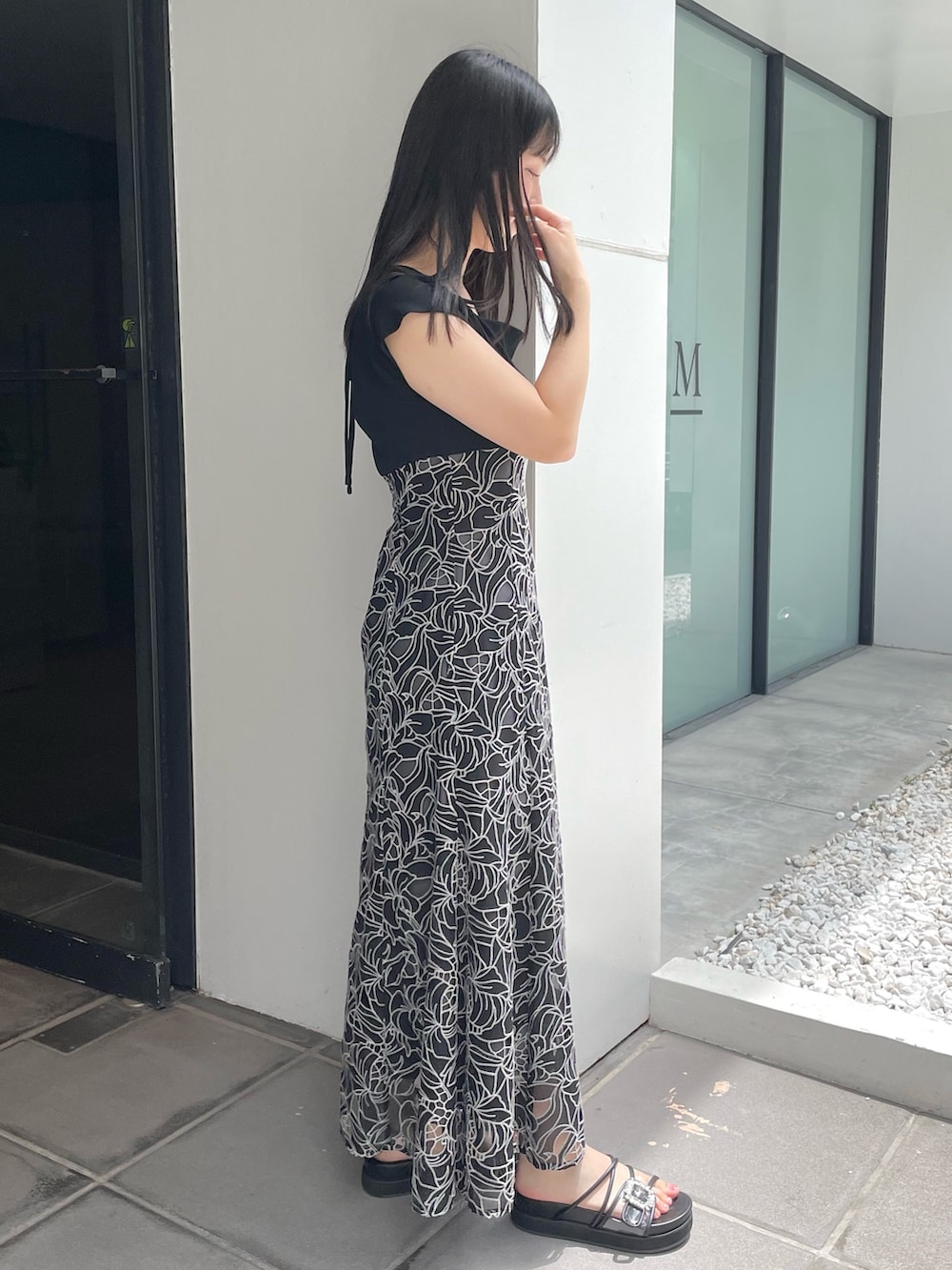 ブラック系のサンダル、ブラック系のワンピースを着用したレディースの夏コーディネートの4枚目の写真