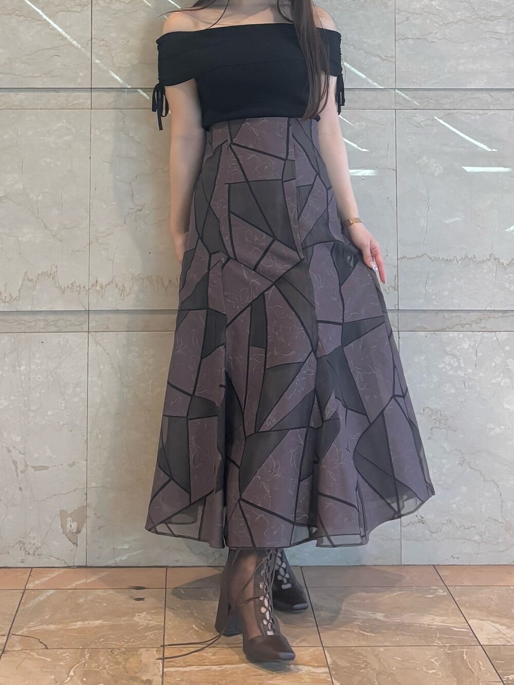 ブラウン系のブーツ、ブラウン系のスカート、ブラック系のニット/セーターを着用したレディースの夏コーディネートの5枚目の写真