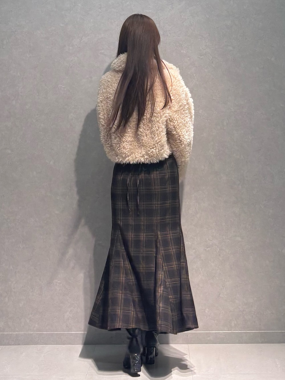 ブラウン系のスカート、ホワイト系のニット/セーター、ベージュ系のその他アウターを着用したレディースの秋コーディネートの5枚目の写真