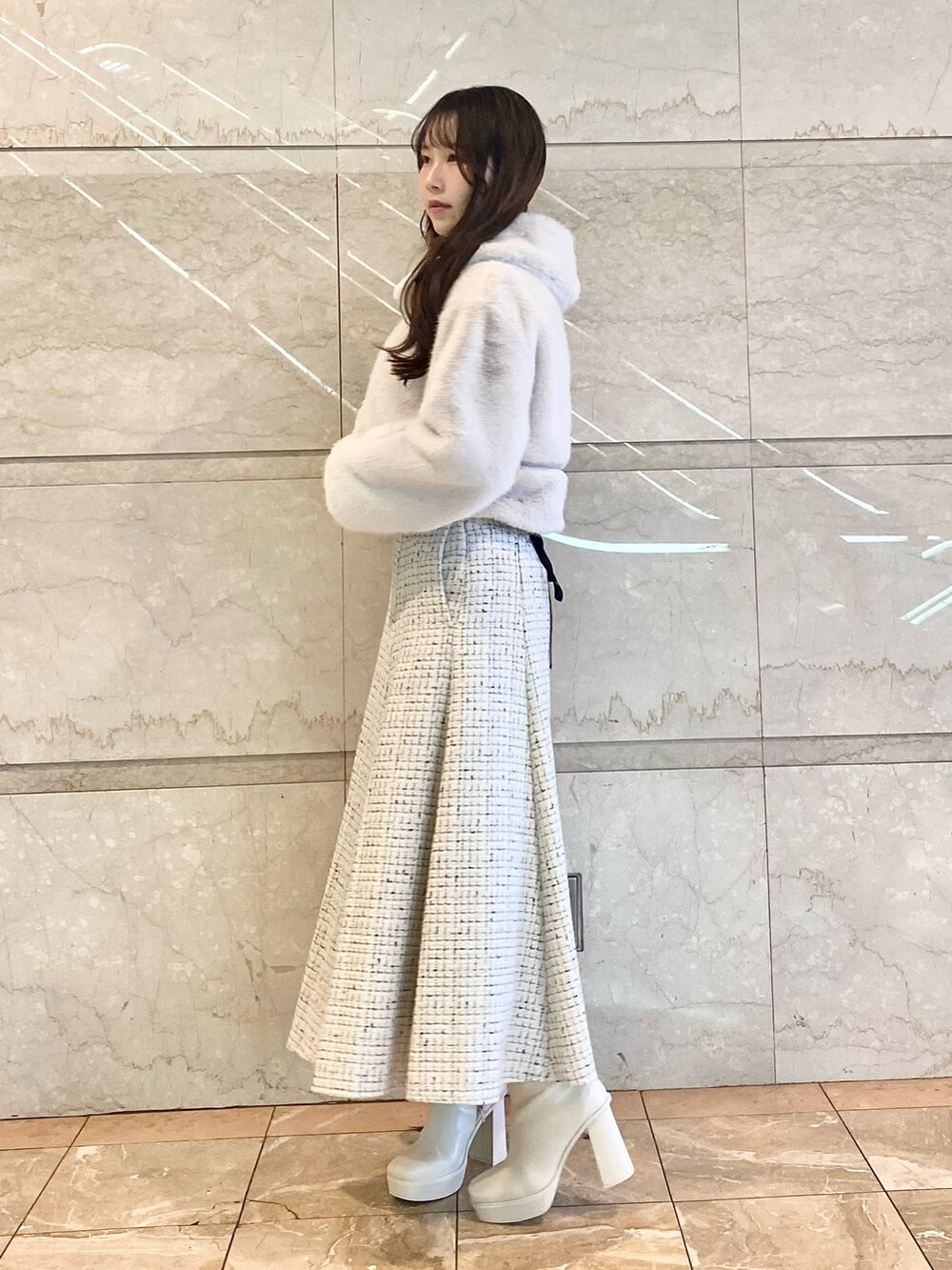 ホワイト系のスカート、ホワイト系のその他アウター、ブラック系のニット/セーターを着用したレディースの秋コーディネートの4枚目の写真