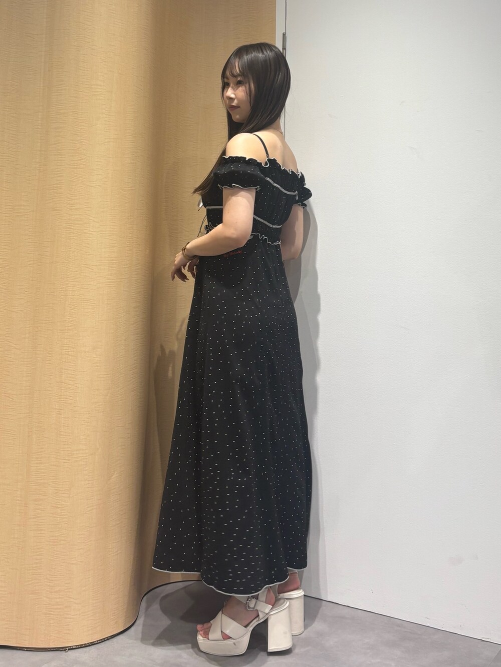 ホワイト系のサンダル、ブラック系のワンピースを着用したレディースの夏コーディネートの3枚目の写真