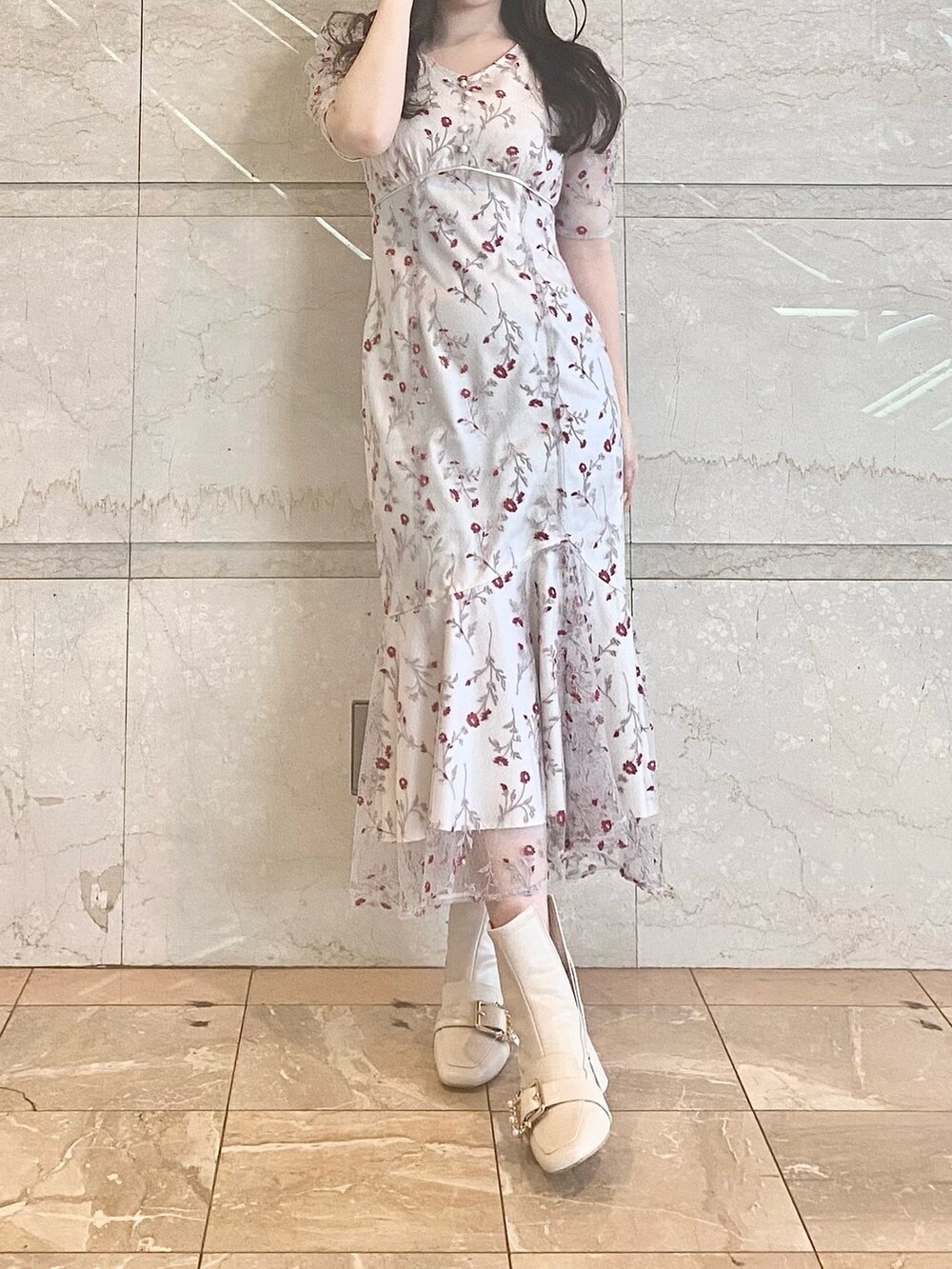 レッド系のワンピース、ホワイト系のブーツを着用したレディースの春コーディネートの2枚目の写真