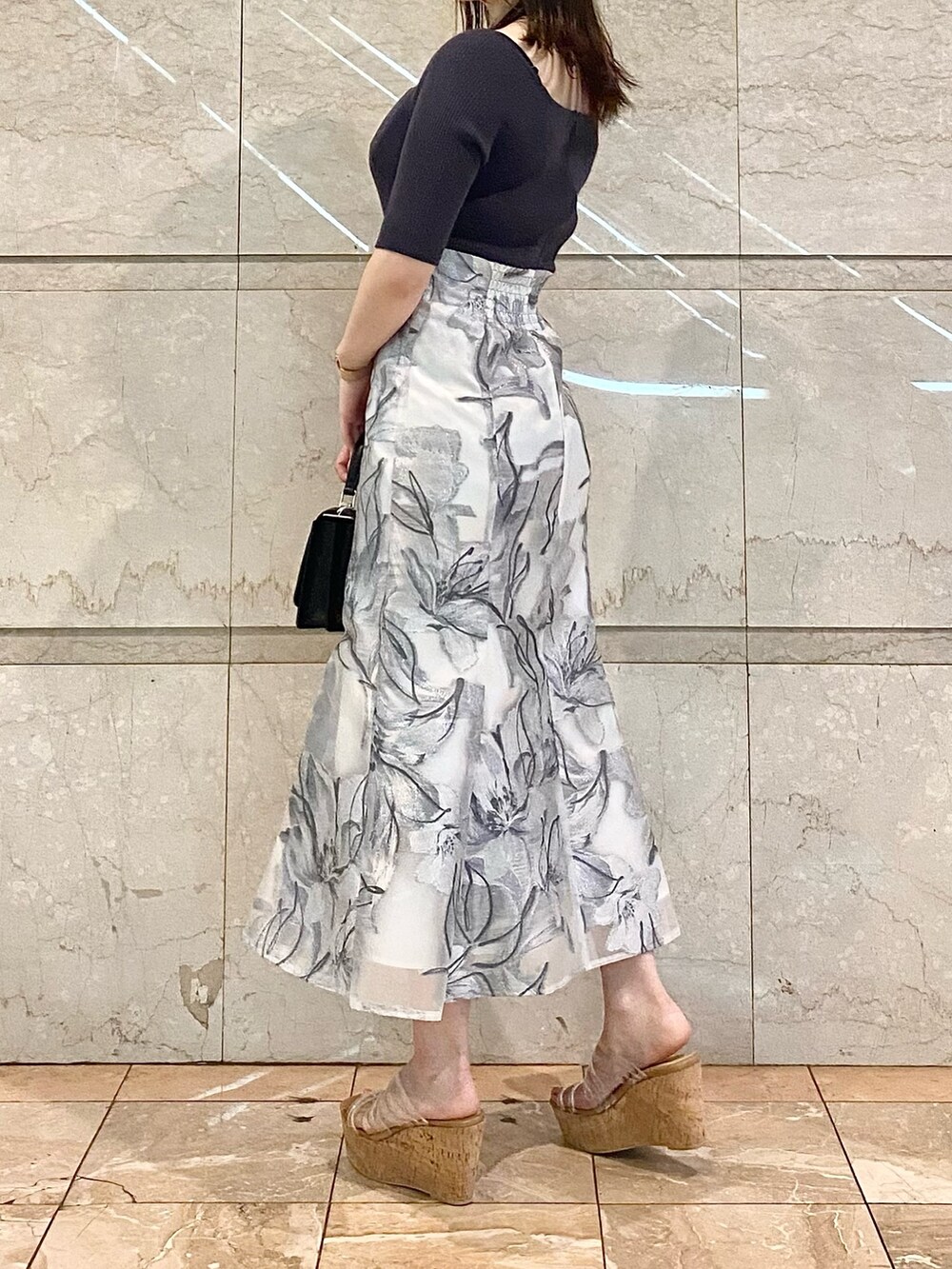 ホワイト系のショルダーバッグ、グレー系のワンピース、その他のサンダルを着用したレディースの春コーディネートの3枚目の写真