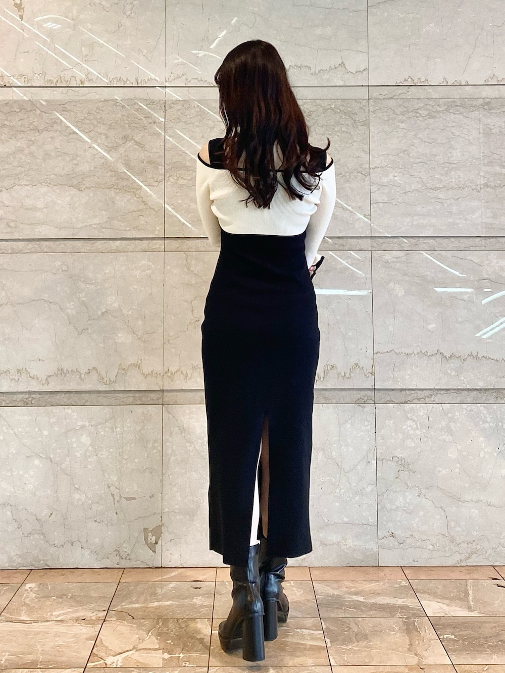 ブラック系のワンピース、ブラック系のブーツを着用したレディースの秋コーディネートの3枚目の写真