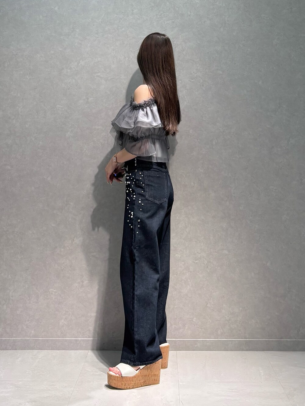 ブルー系のデニムパンツ、グレー系のシャツ/ブラウス、ホワイト系のサンダルを着用したレディースの夏コーディネートの4枚目の写真