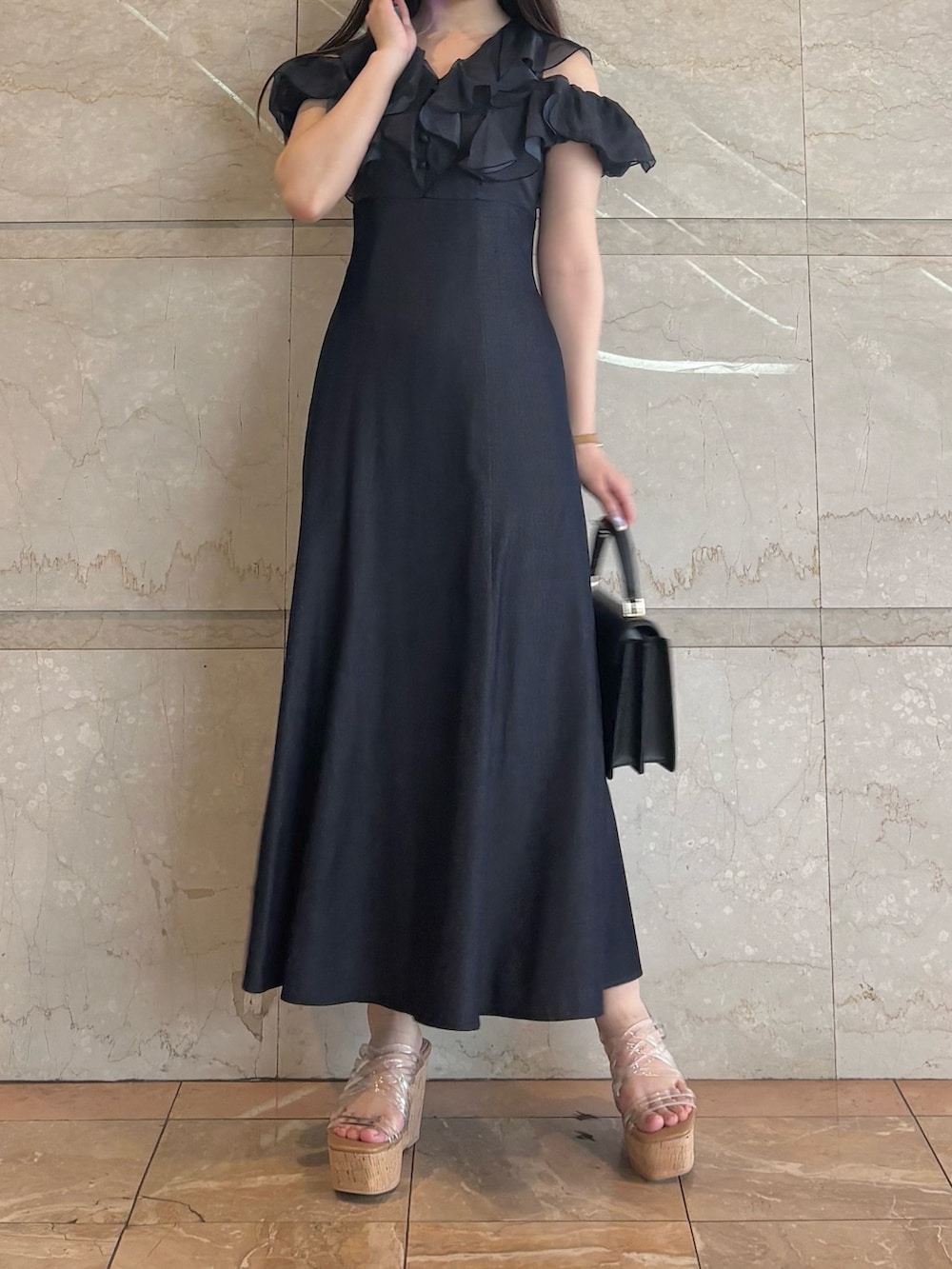 ブルー系のワンピース、その他のサンダル、ブラック系のハンドバッグを着用したレディースの夏コーディネートの2枚目の写真