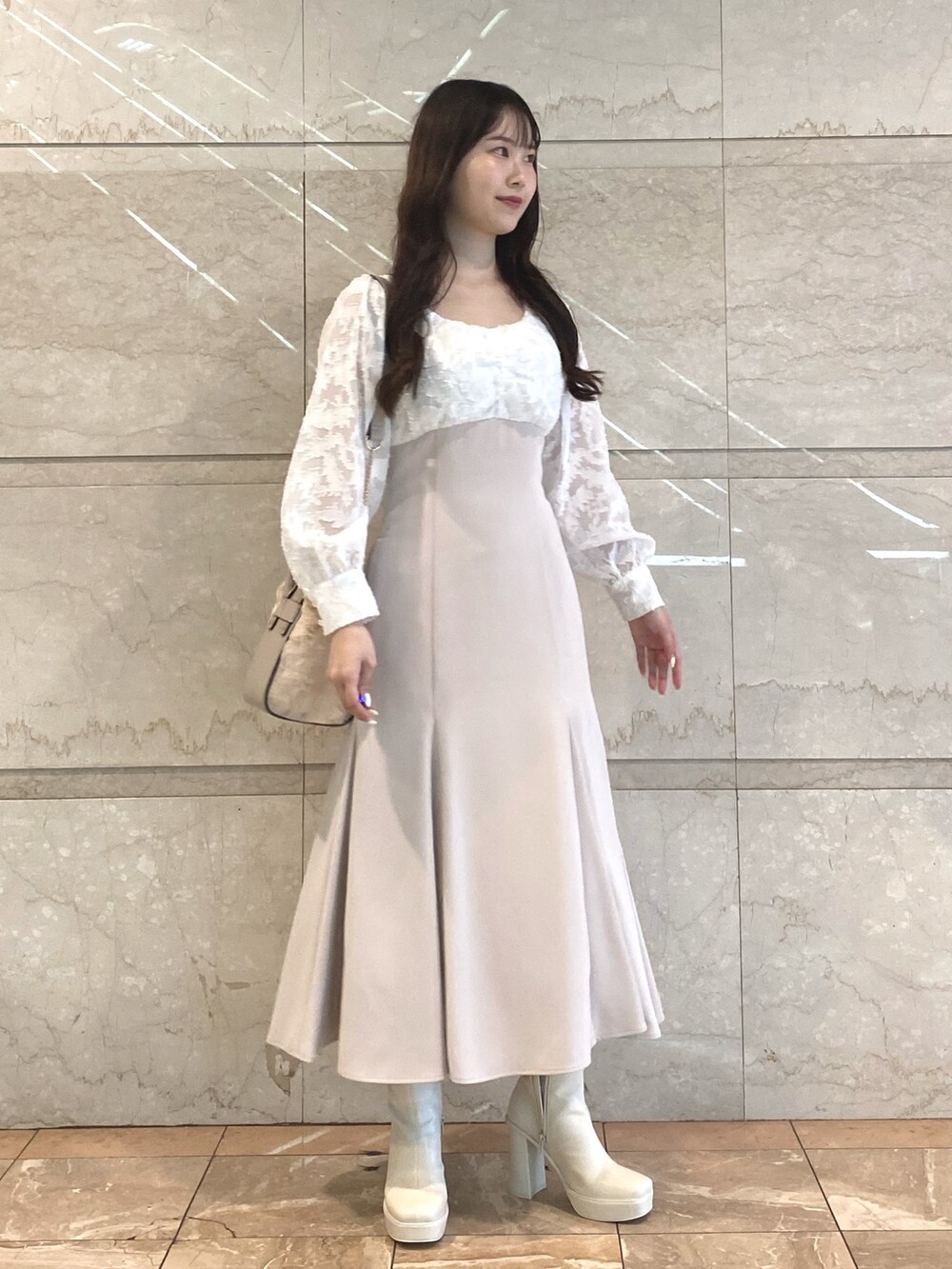 ピンク系のワンピース、ホワイト系のハンドバッグ、ホワイト系のブーツを着用したレディースの秋コーディネートの5枚目の写真