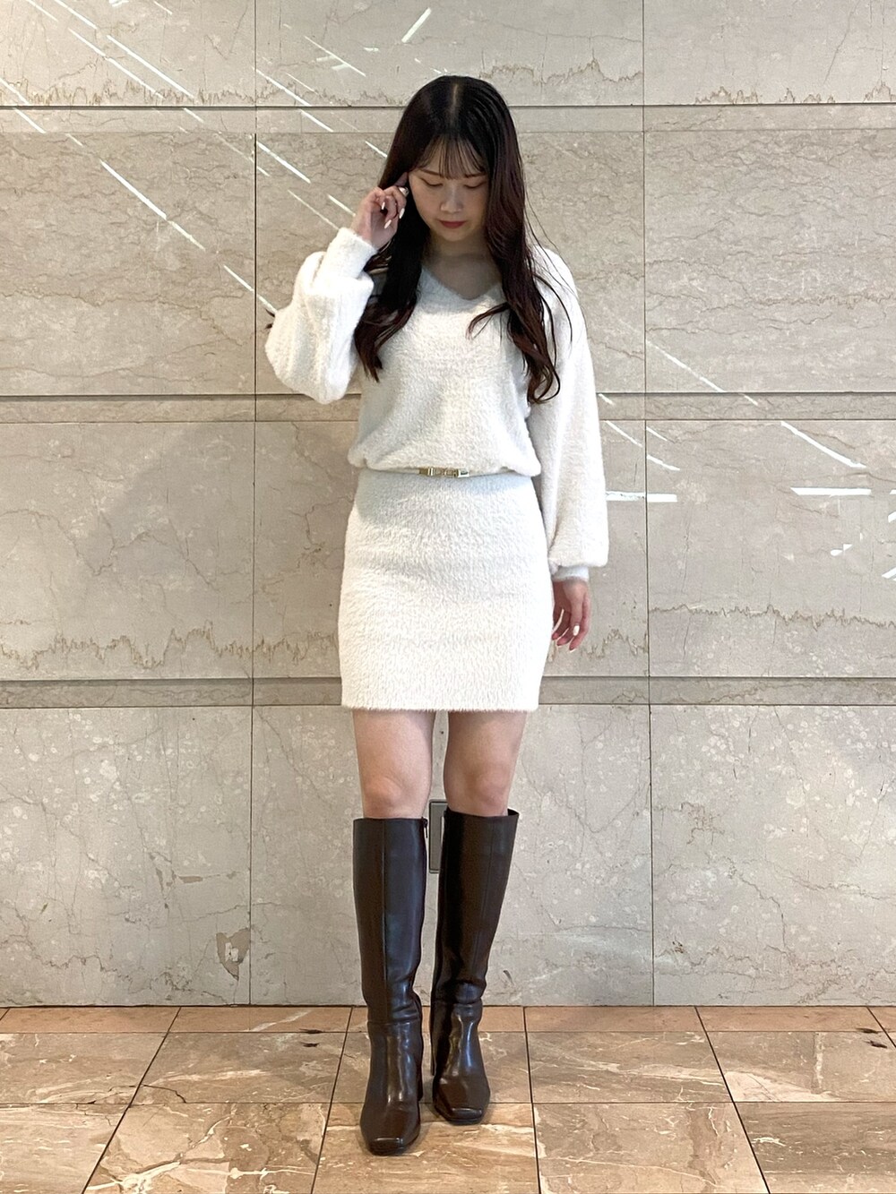 ホワイト系のワンピース、ブラウン系のブーツ、ホワイト系のベルトを着用したレディースの秋コーディネートの3枚目の写真