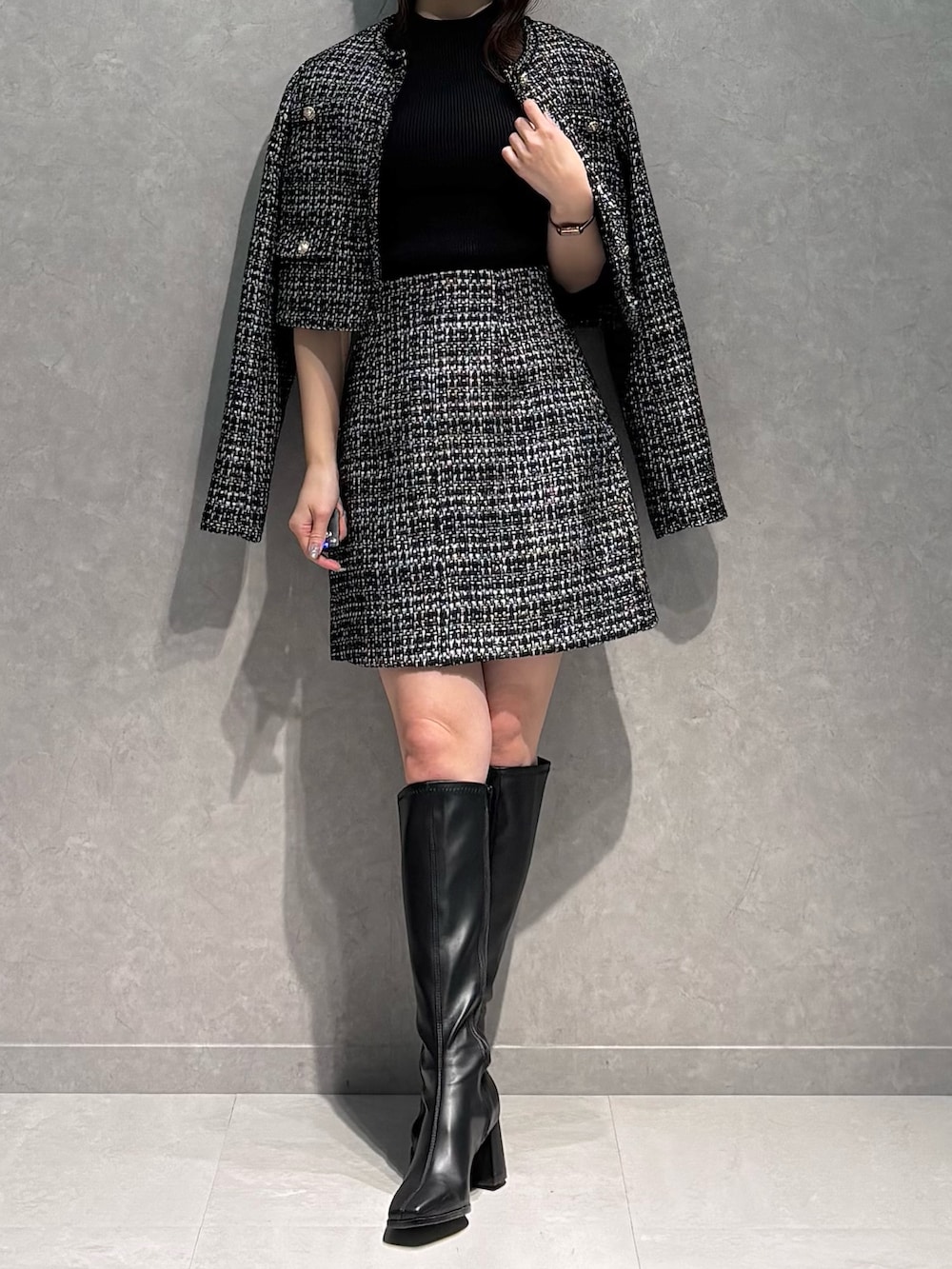 ブラック系のスカート、ブラック系のニット/セーター、ブラック系のテーラードジャケットを着用したレディースの春コーディネートの2枚目の写真