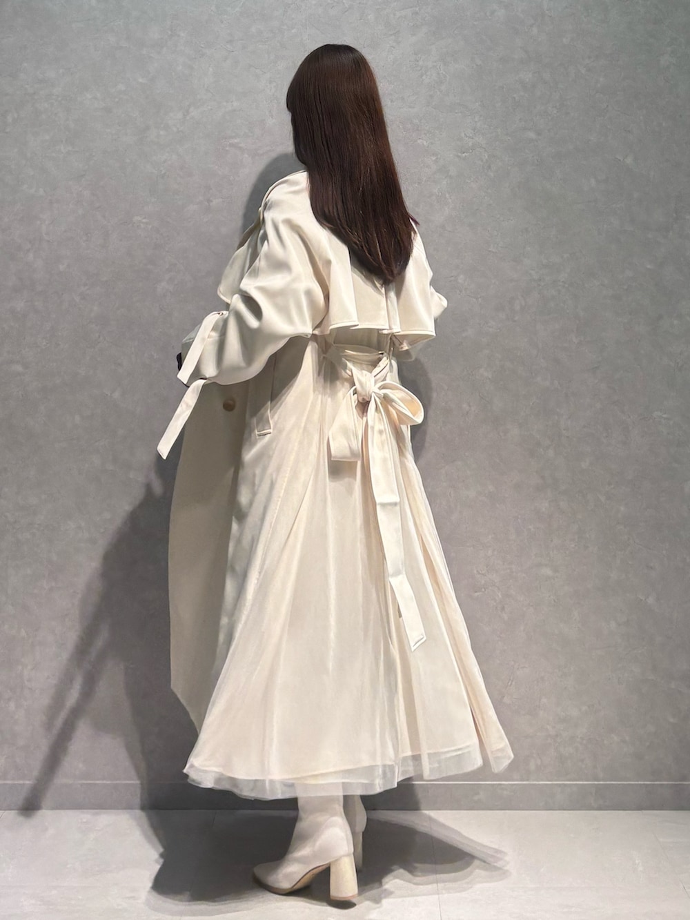 グリーン系のスカート、ホワイト系のブーツ、ブラウン系のニット/セーターを着用したレディースの春コーディネートの4枚目の写真