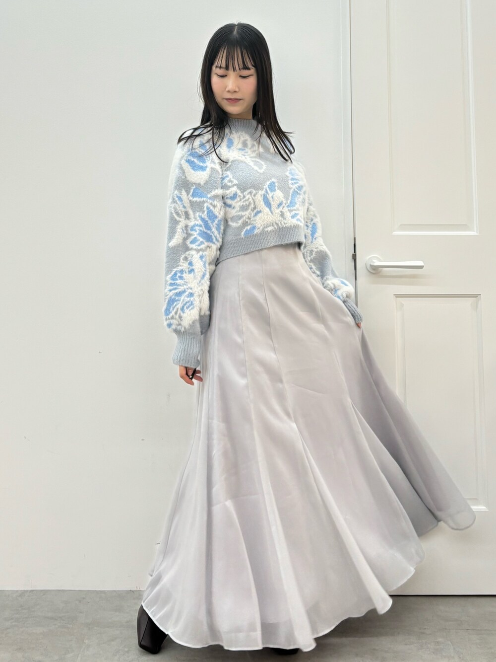 ブルー系のニット/セーター、ブラウン系のブーツ、グレー系のスカートを着用したレディースの秋コーディネートの3枚目の写真