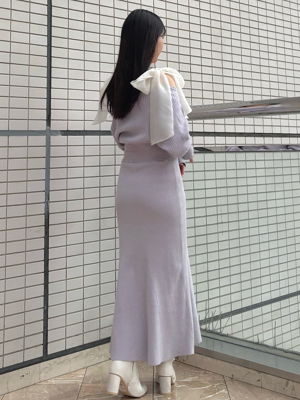 パープル系のワンピース、ホワイト系のブーツを着用したレディースの冬コーディネートの4枚目の写真