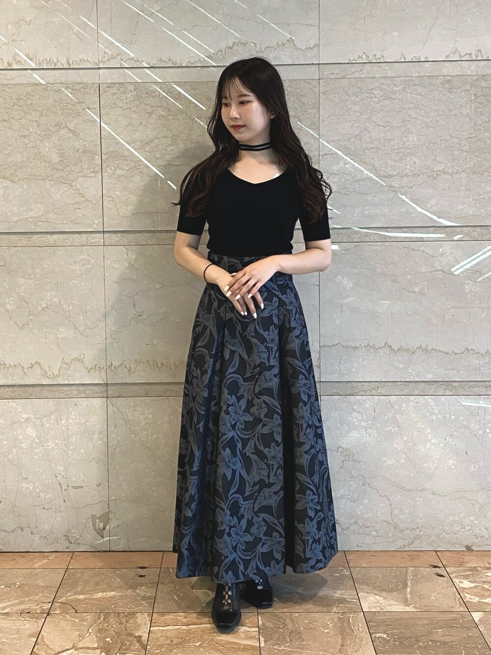 グレー系のスカート、ブラック系のブーツ、ホワイト系のニット/セーターを着用したレディースの秋コーディネートの6枚目の写真