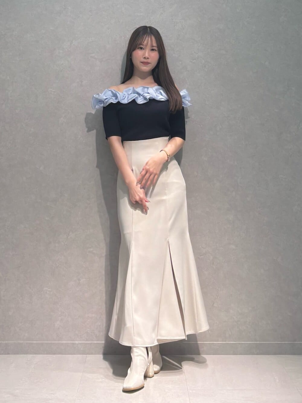 ホワイト系のブーツ、ホワイト系のスカート、ブルー系のニット/セーターを着用したレディースの春コーディネートの4枚目の写真