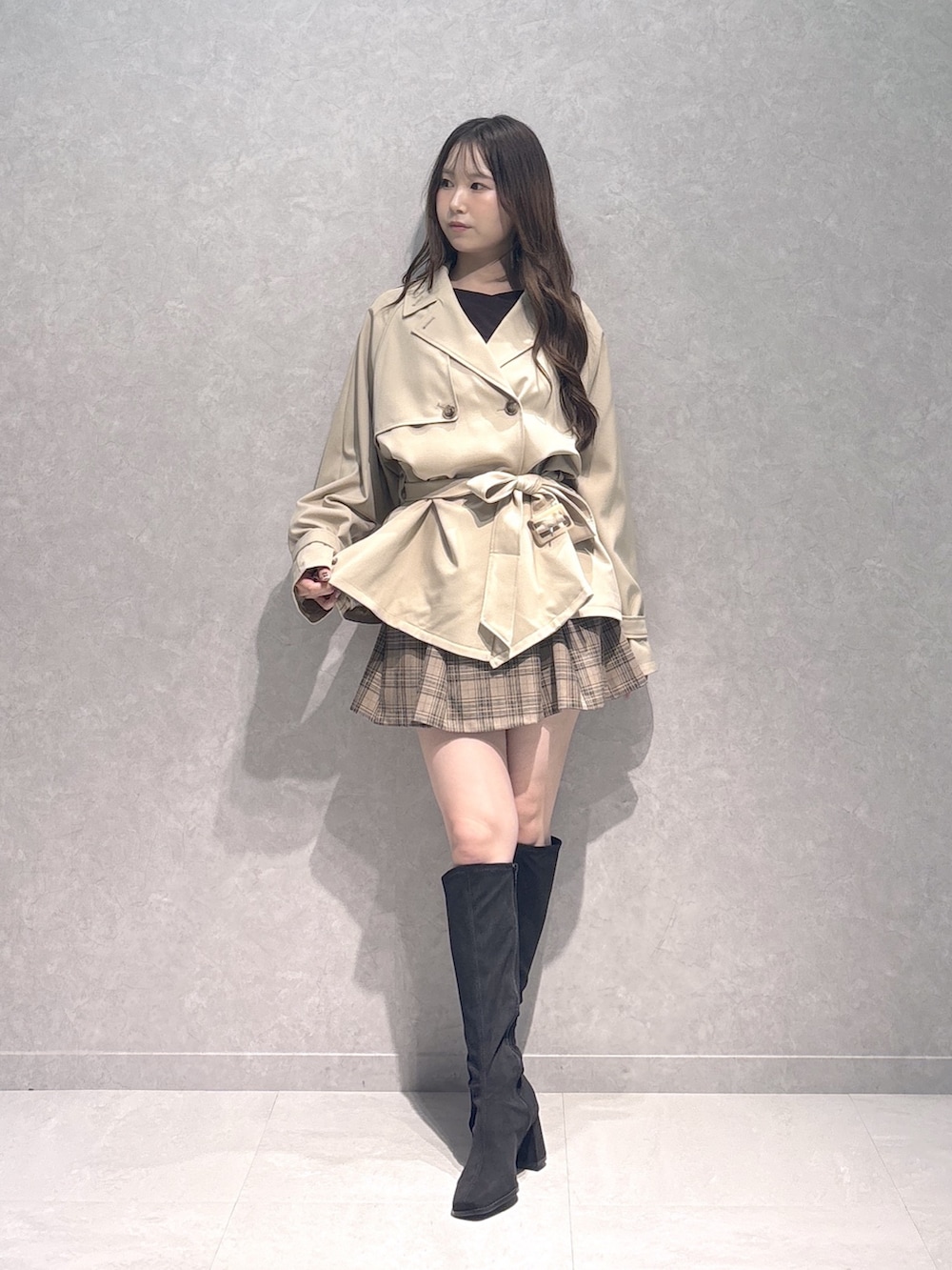 ベージュ系のスカート、ブラウン系のTシャツ/カットソー、ベージュ系のトレンチコートを着用したレディースの秋コーディネートの4枚目の写真