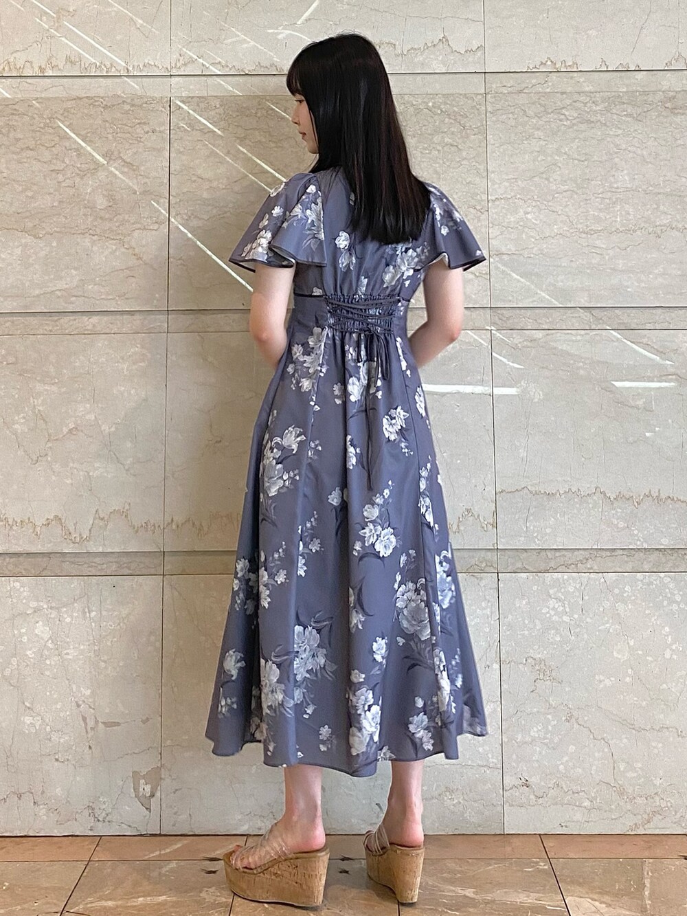 ホワイト系のハンドバッグ、グレー系のワンピース、その他のサンダルを着用したレディースの夏コーディネートの3枚目の写真