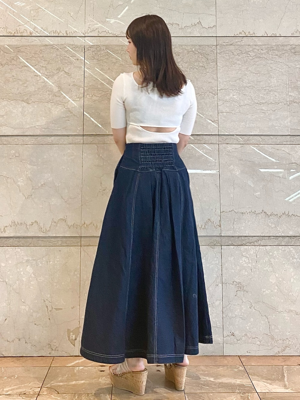ブルー系のスカート、ホワイト系のニット/セーター、その他のサンダルを着用したレディースの春コーディネートの5枚目の写真