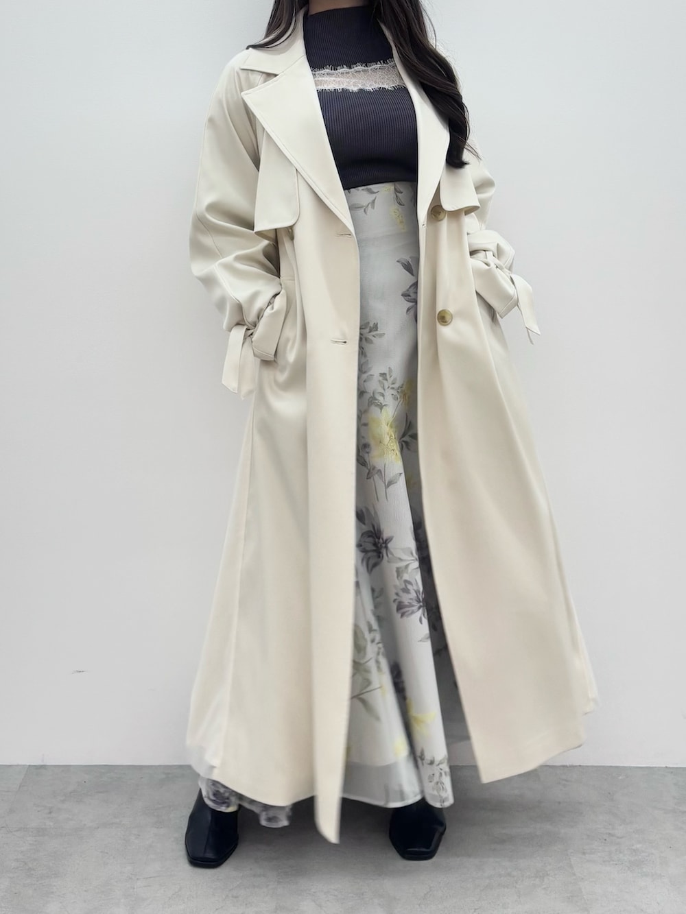 ブラック系のブーツ、グレー系のニット/セーター、ホワイト系のトレンチコートを着用したレディースの冬コーディネートの2枚目の写真