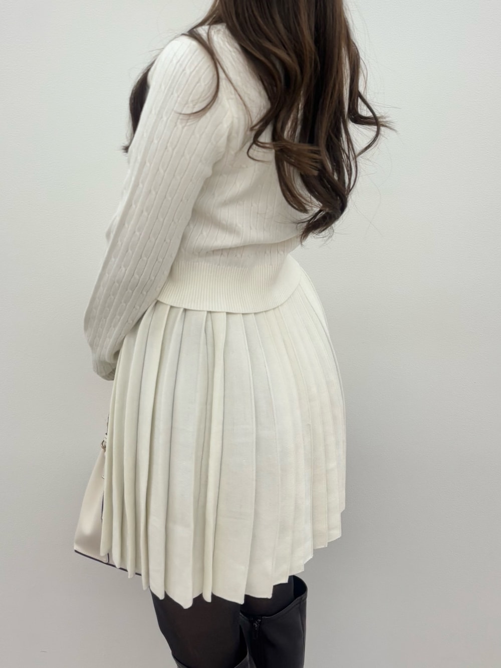 ブラウン系のブーツ、ホワイト系のショルダーバッグ、ホワイト系のワンピースを着用したレディースの冬コーディネートの5枚目の写真