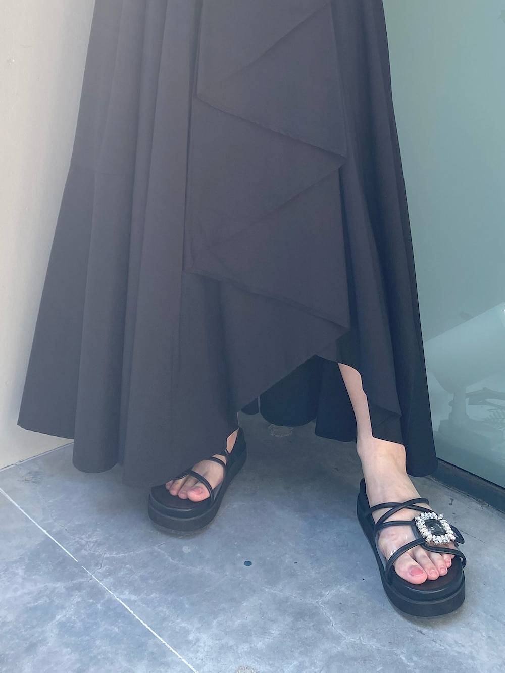 ブラック系のショルダーバッグ、ブラック系のサンダル、ブラック系のスカートを着用したレディースの夏コーディネートの5枚目の写真