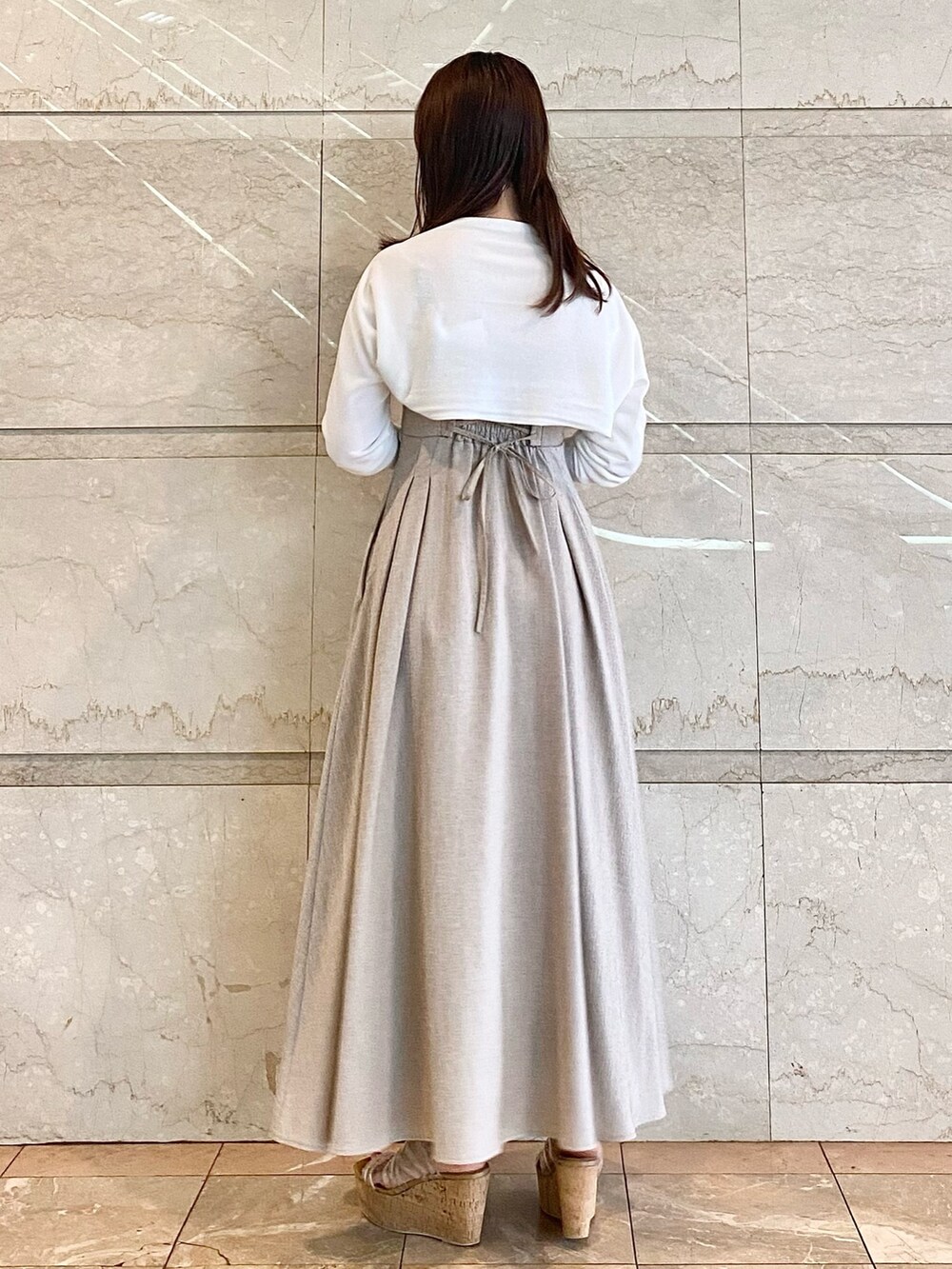 ベージュ系のワンピース、ホワイト系のカーディガン/ボレロ、その他のサンダルを着用したレディースの春コーディネートの5枚目の写真