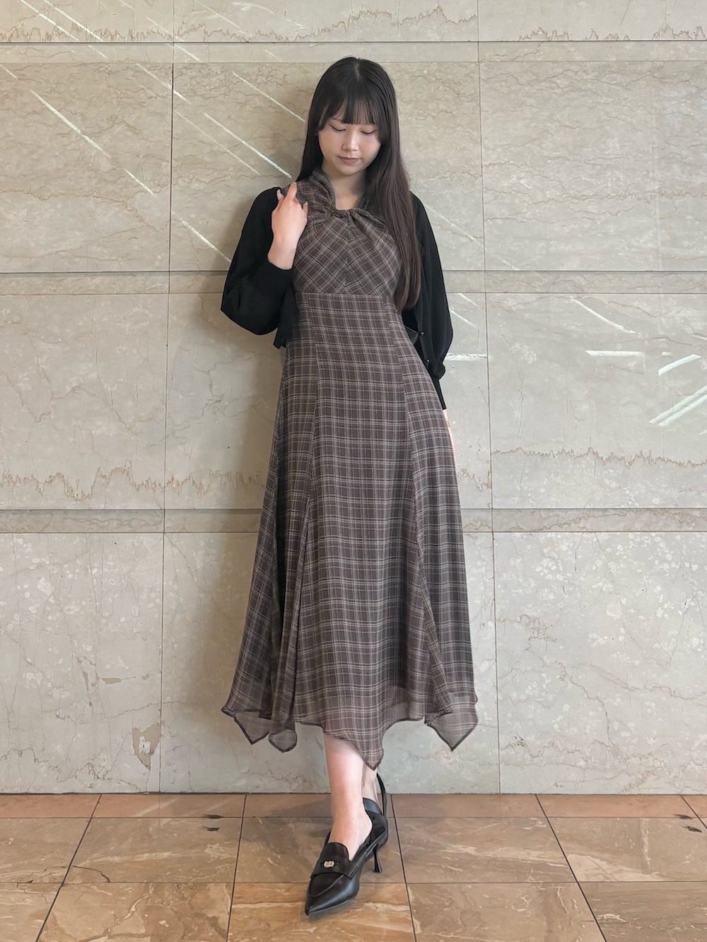 ブラウン系のワンピース、ブラック系のパンプス、ブラック系のカーディガン/ボレロを着用したレディースの夏コーディネートの2枚目の写真