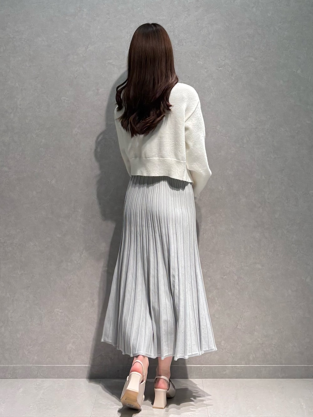 グレー系のワンピース、ホワイト系のカーディガン/ボレロ、ホワイト系のパンプスを着用したレディースの春コーディネートの5枚目の写真