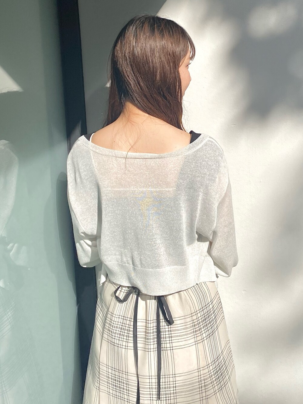 ブラック系のワンピース、ホワイト系のサンダル、ホワイト系のカーディガン/ボレロを着用したレディースの夏コーディネートの3枚目の写真