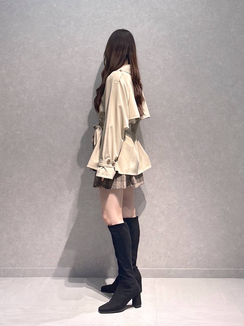 ベージュ系のスカート、ブラウン系のTシャツ/カットソー、ベージュ系のトレンチコートを着用したレディースの秋コーディネートの5枚目の写真