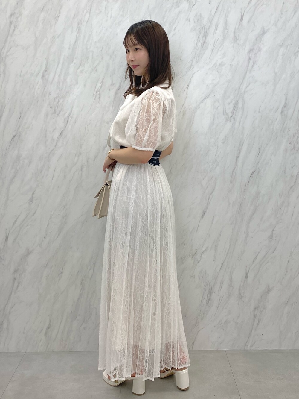 ベージュ系のショルダーバッグ、ホワイト系のサンダル、ホワイト系のシャツ/ブラウスを着用したレディースの夏コーディネートの4枚目の写真