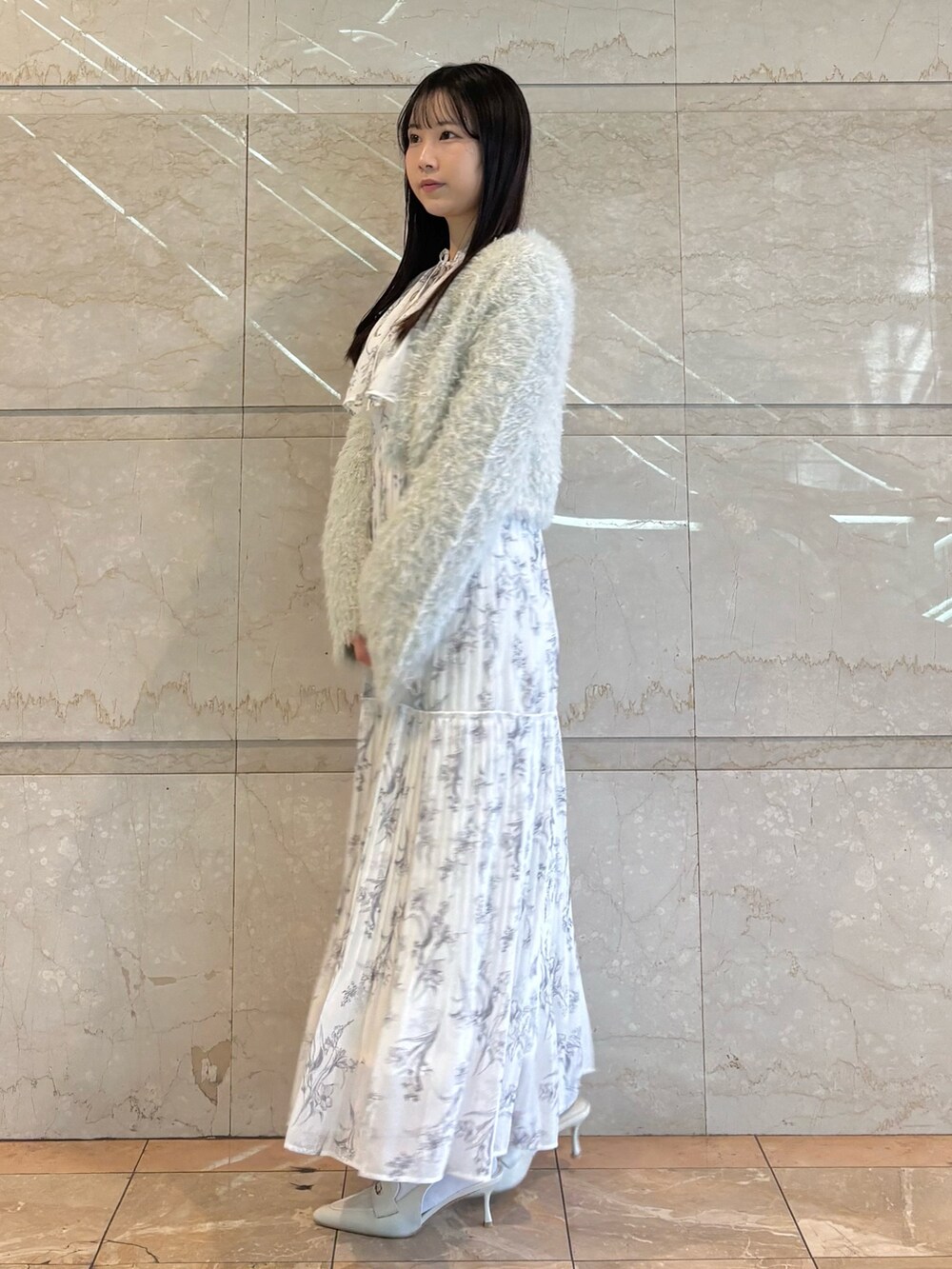 ホワイト系のワンピース、ホワイト系のパンプス、グリーン系のカーディガン/ボレロを着用したレディースの冬コーディネートの4枚目の写真