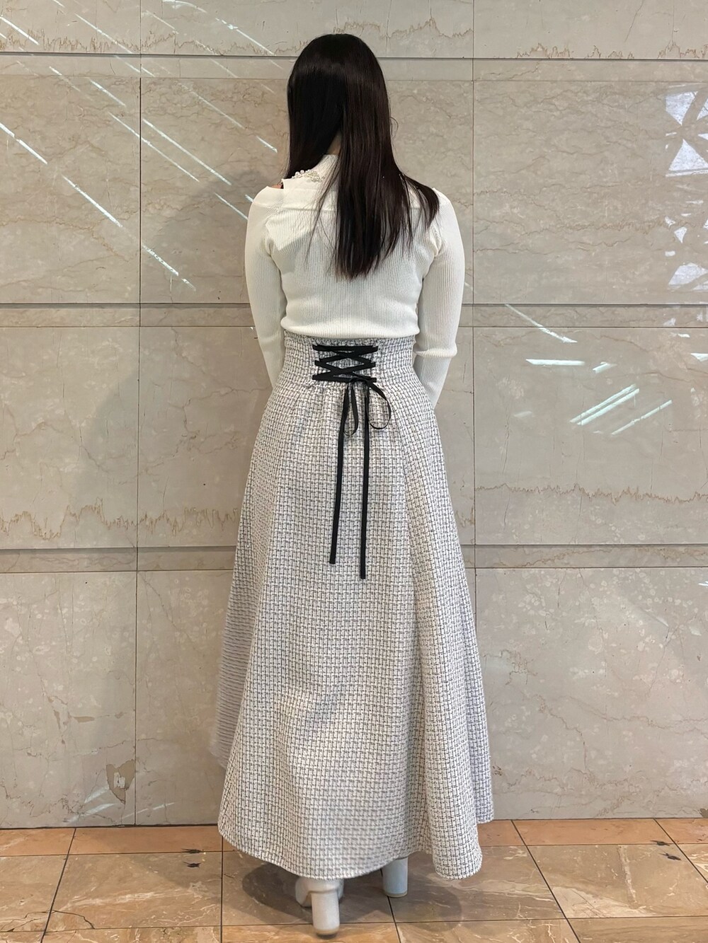 ホワイト系のスカート、ホワイト系のブーツ、ホワイト系のニット/セーターを着用したレディースの冬コーディネートの2枚目の写真