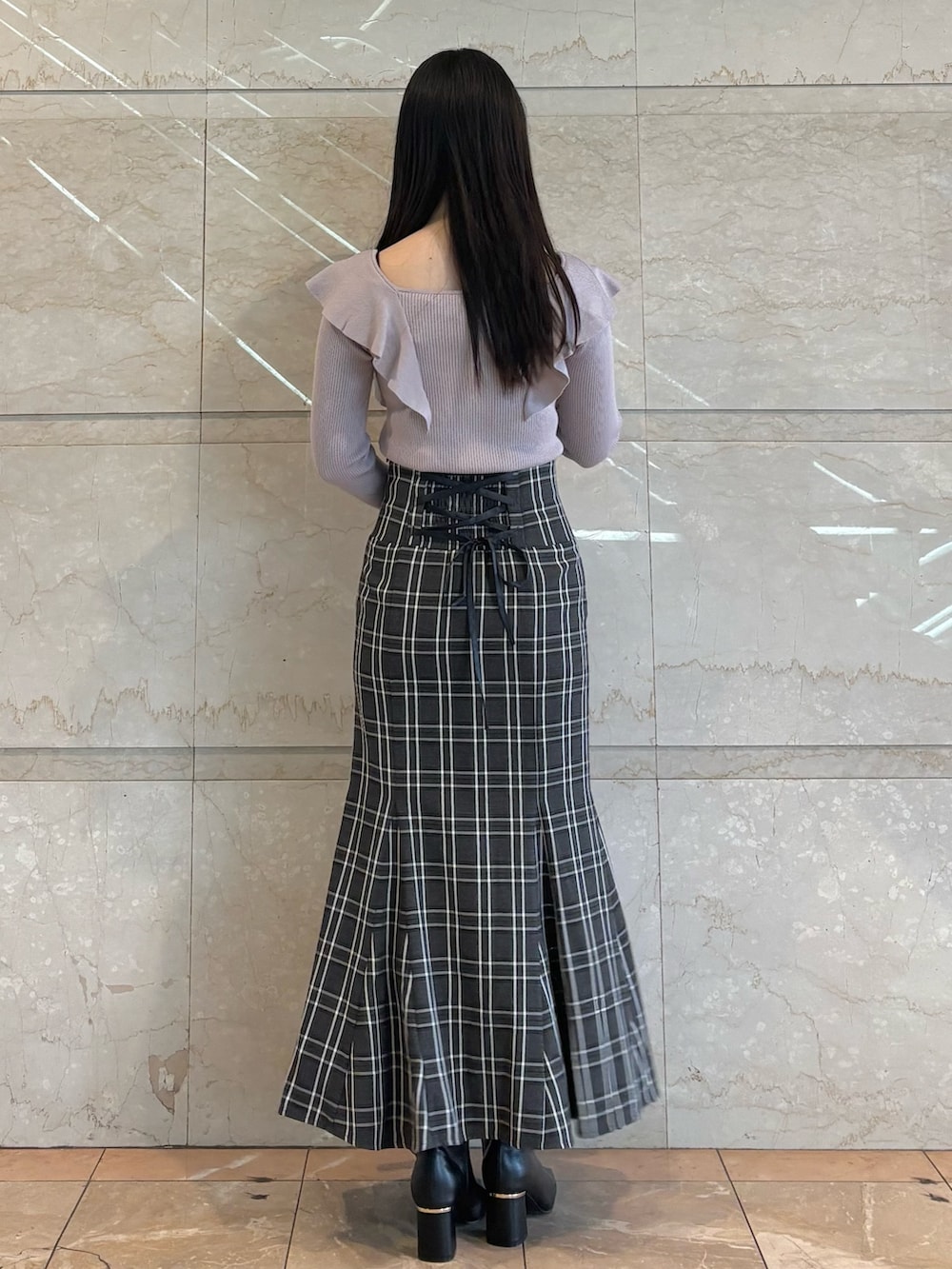 ピンク系のハンドバッグ、ブラック系のブーツ、その他のスカートを着用したレディースの冬コーディネートの4枚目の写真