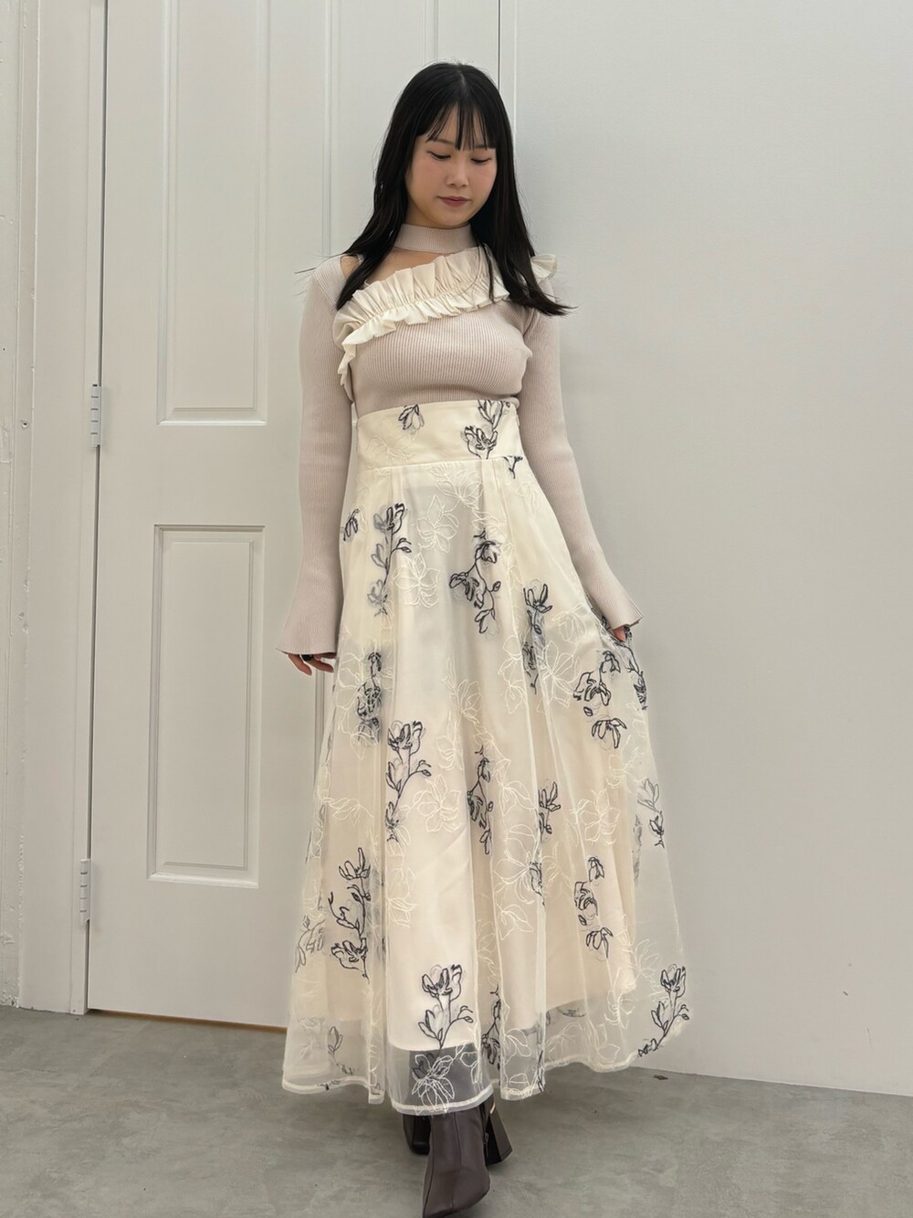 ホワイト系のスカート、ブラウン系のブーツ、ホワイト系のニット/セーターを着用したレディースの秋コーディネートの2枚目の写真